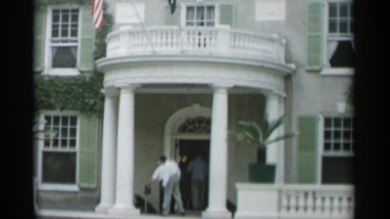 Columned building entrance with people walking into the doorway.
