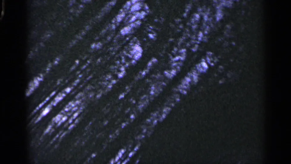Abstract 1960 Duluth frame showing a dark close-up with purple-blue reflective streaks, likely from the same film sequence.