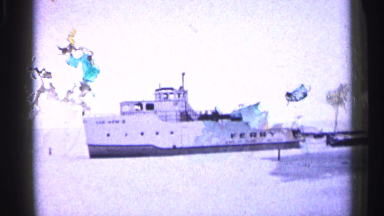 White ferry on frozen water with heavy exposure flare and film damage at frame edge.