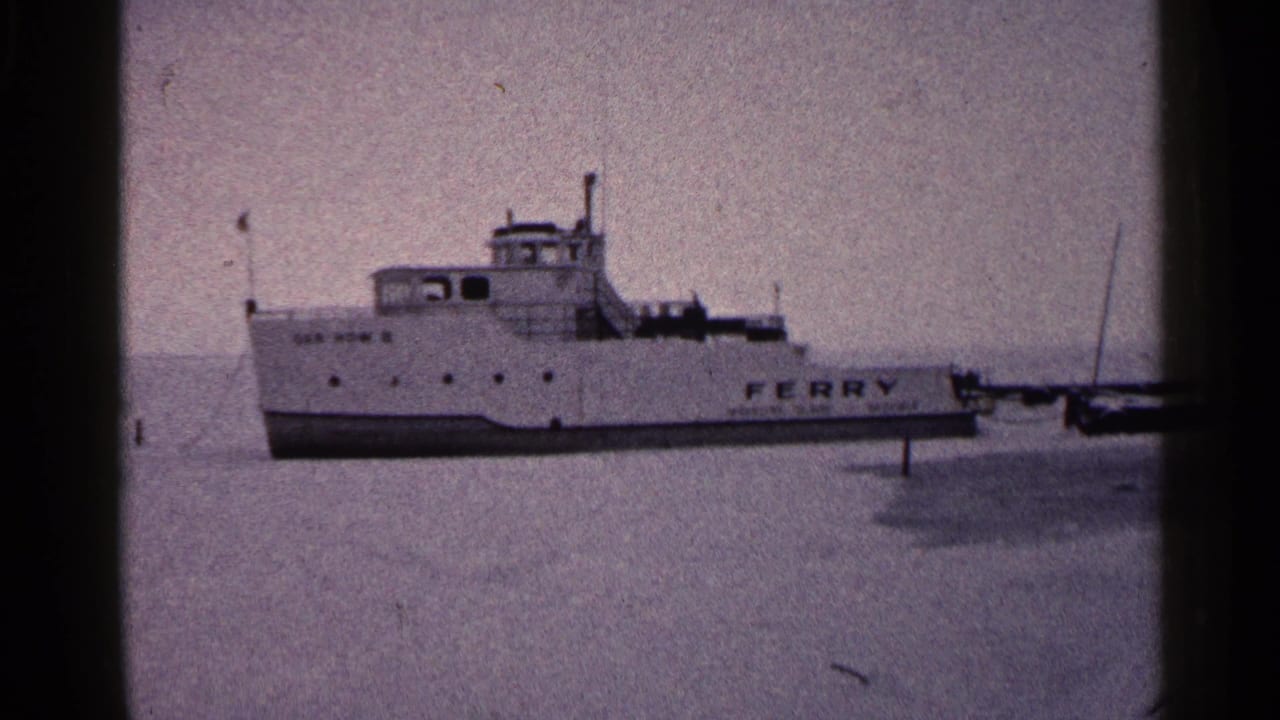 White ferry on a frozen lake with FERRY lettering visible on the hull.