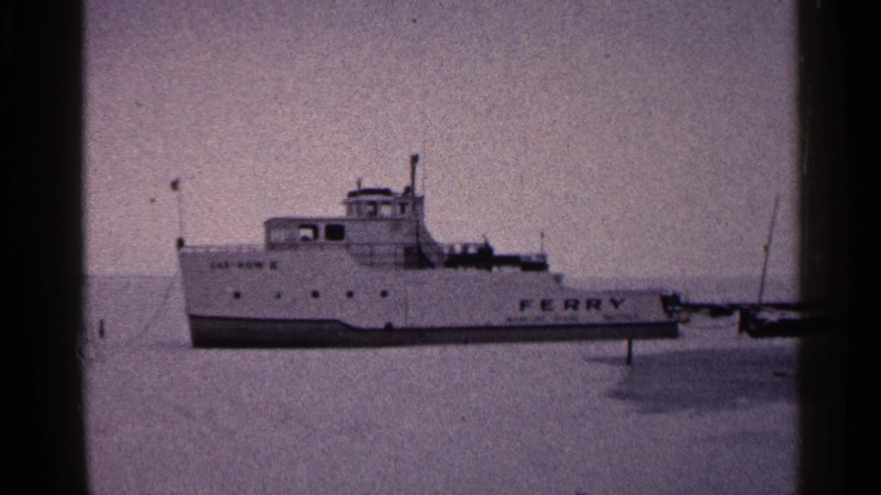 White ferry across a frozen lake with large FERRY lettering on the side.