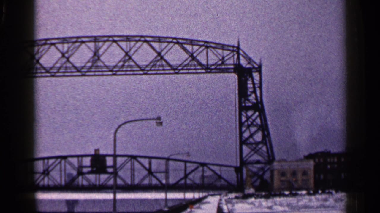 Steel lift bridge and lower bridge span seen in a snowy winter waterfront scene.