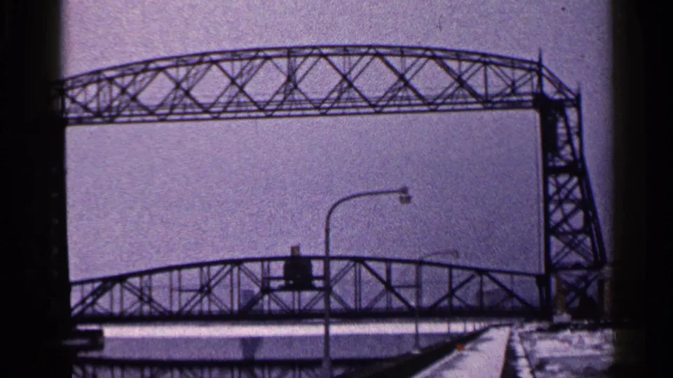 The final frame holds on the Duluth Aerial Lift Bridge in winter, showing the truss, tower, lower bridge, snow, and 8mm border marks.