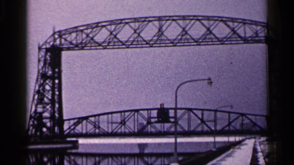 Duluth winter bridge view with the truss span crossing the frame and a streetlight in the snowy foreground.