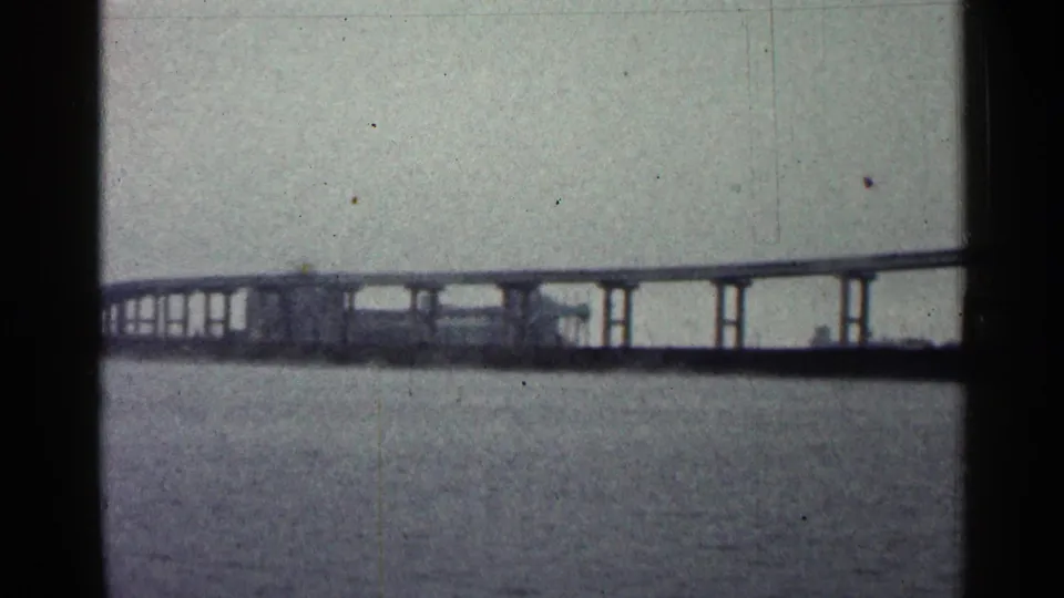 Distant Duluth bridge structure on pilings, with repeating supports visible across the water.