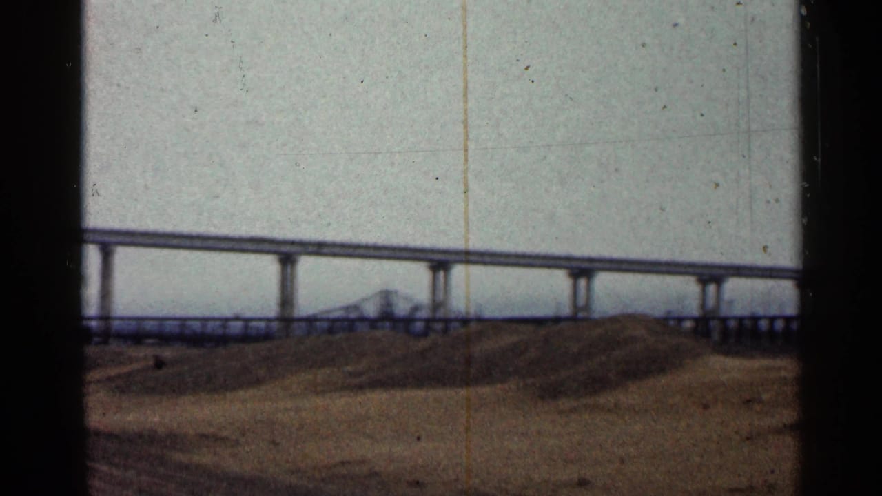 1960 Duluth home-movie view of a long bridge span with a smaller truss form visible in the distance over the waterfront.