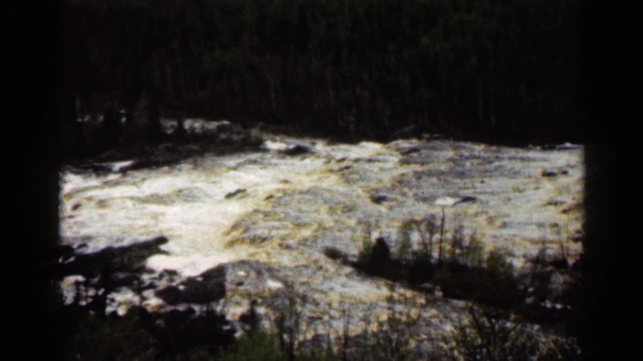 Rushing river at Jay Cooke State Park, Minnesota, seen in grainy 1960 Super 8 with forested banks behind it.