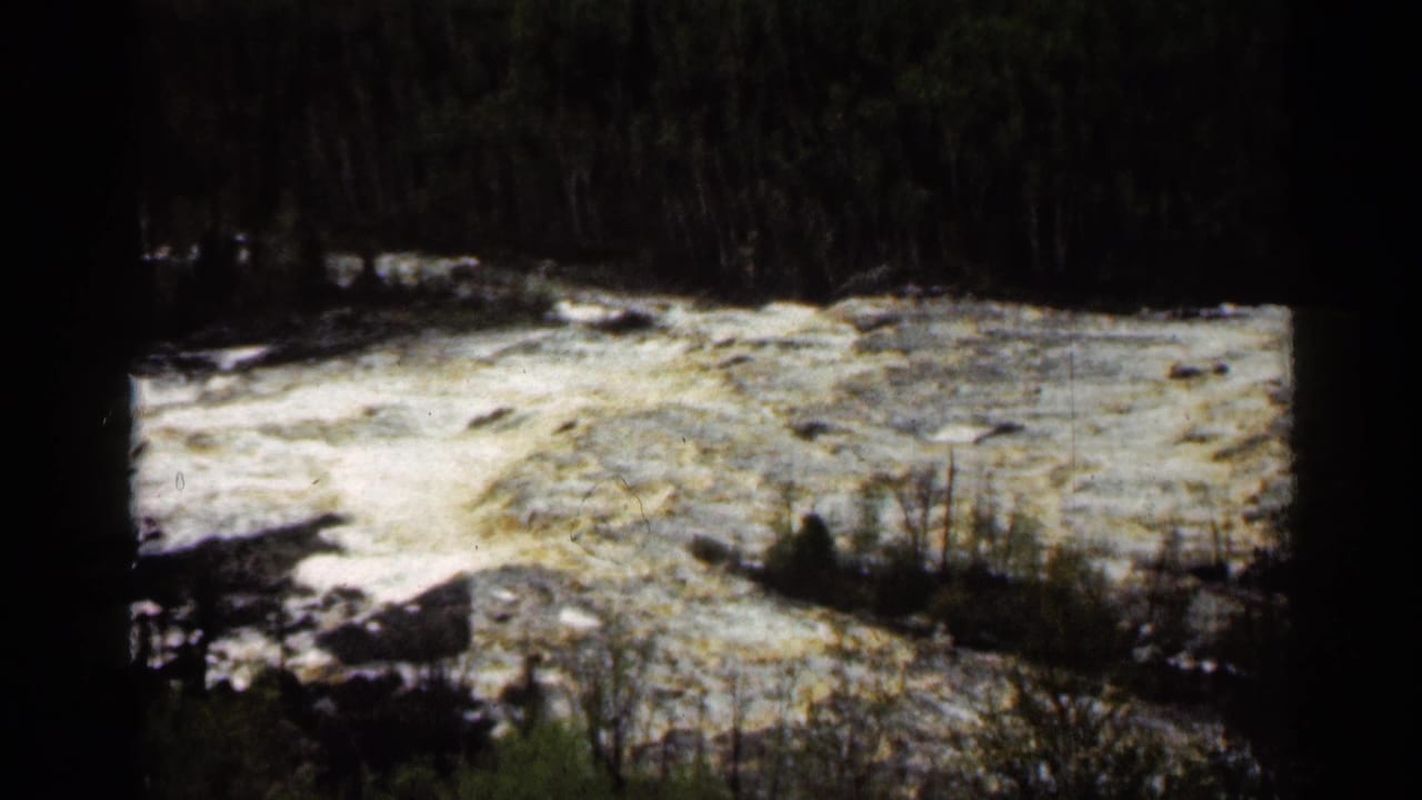 Vintage Super 8 view of turbulent river water and brush at Jay Cooke State Park in Minnesota.