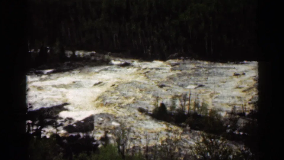 Vintage Super 8 view of turbulent river water and brush at Jay Cooke State Park in Minnesota.