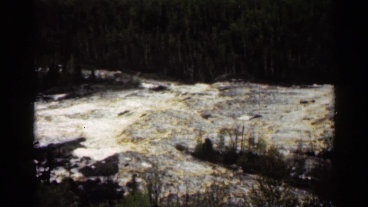 1960 Super 8 frame of white water rushing through a forested river scene at Jay Cooke State Park, Minnesota.
