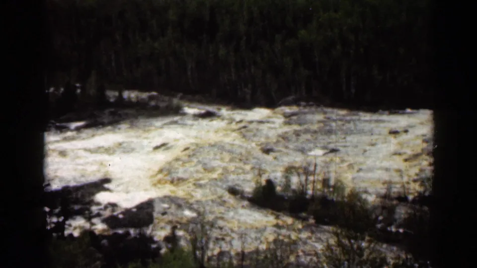 1960 Super 8 frame of white water rushing through a forested river scene at Jay Cooke State Park, Minnesota.