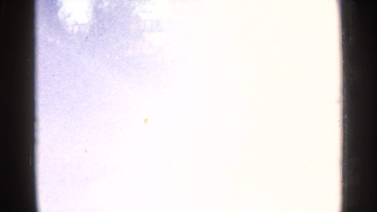 Bright overexposed film frame with little visible detail at the edge of the reel.