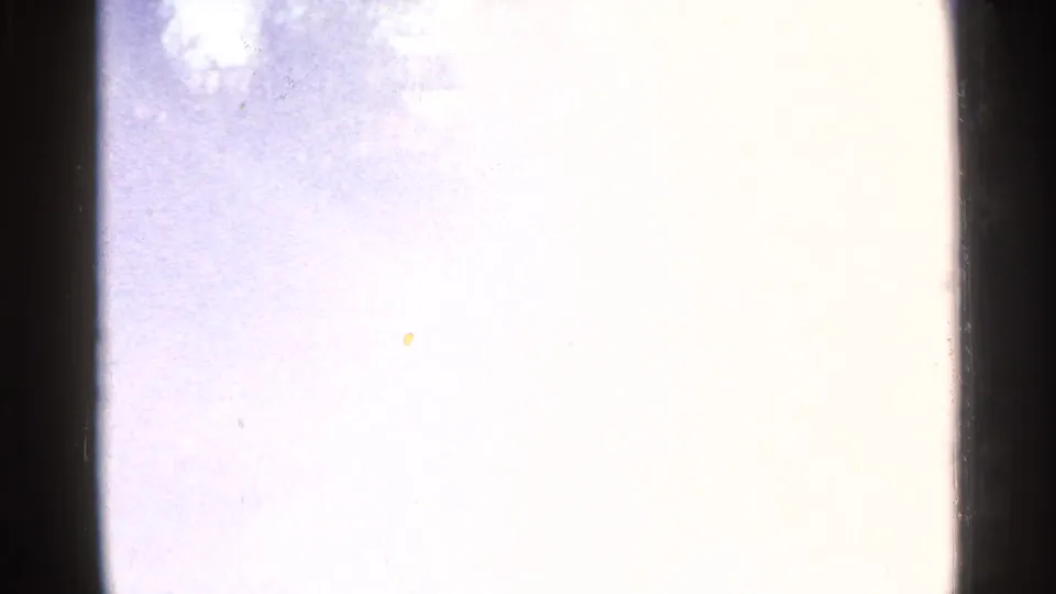 Mostly overexposed 8mm frame with faint color and edge shadows, likely between visible views of the Sioux Falls stream scene.