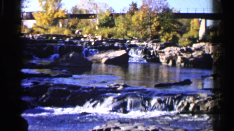The final view shows a rocky Sioux Falls stream and low cascades framed by autumn trees and bridge supports on 8mm film.