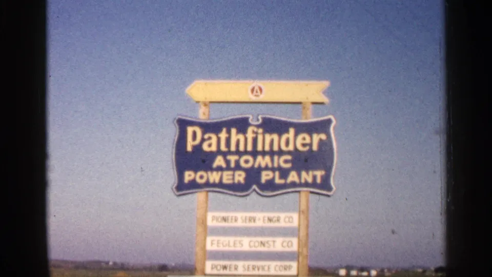 The Pathfinder Atomic Power Plant sign fills the frame, with visible lettering and company panels beneath a clear sky.