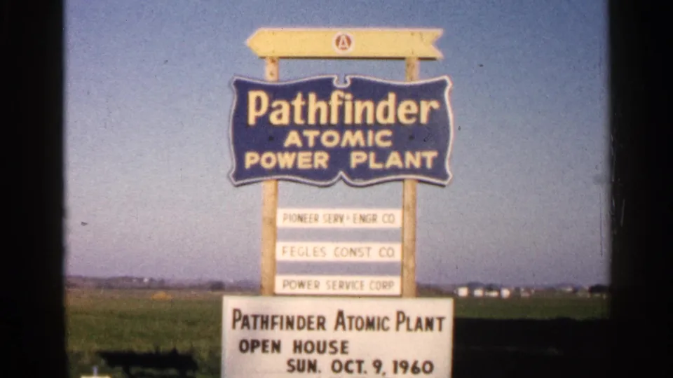 1960 8mm frame showing the Pathfinder Atomic Power Plant sign above a board for the October 9 open house.