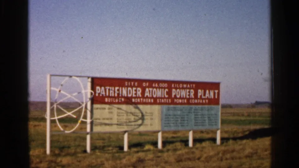 The Pathfinder Atomic Power Plant information sign appears in a wider 8mm frame, set against open grassland and sky near Sioux Falls.