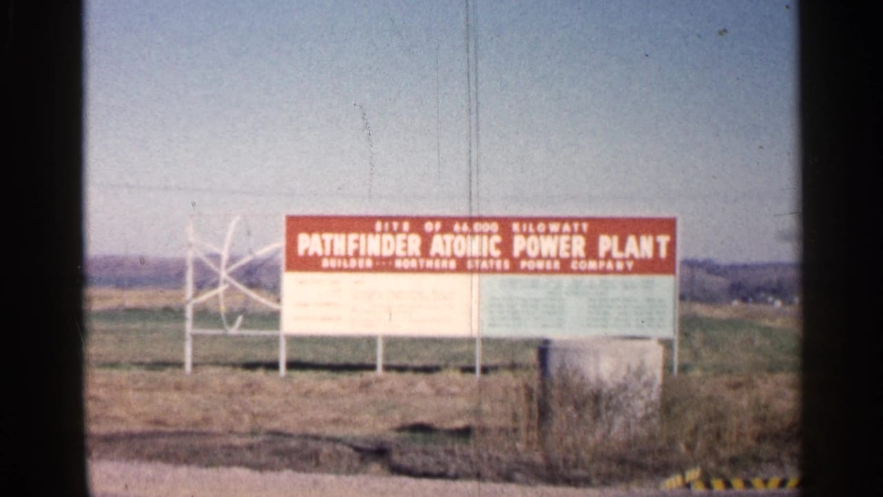 1960 Sioux Falls footage showing a red sign for the Pathfinder Atomic Power Plant in a rural roadside setting.