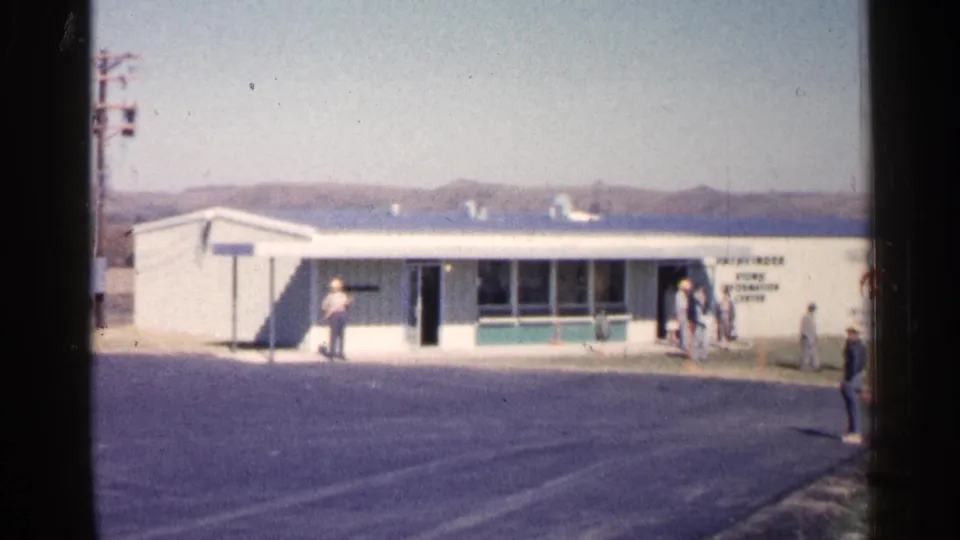 1960 Sioux Falls view of the Pathfinder Atomic Power Plant visitor center, with several people outside the low white building.