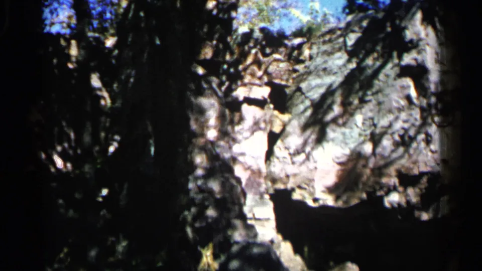 Final frame of the 1960 Sioux Falls clip, showing the rock formation and tree canopy in saturated 8mm color.