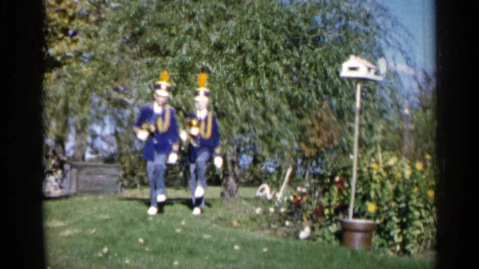 Two uniformed band members appear in a yard with trees and a birdhouse, consistent with the 1960 Sioux Falls metadata.