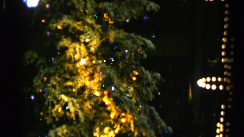 1960 Sioux Falls frame showing the lit tree at another point in its rotation beside a vertical strand with cross-like bulb shapes.