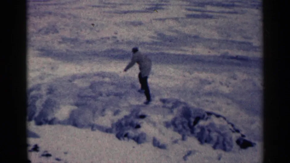 A bundled man crosses the icy ground with an arm out, suggesting careful footing on the frozen Duluth landscape.