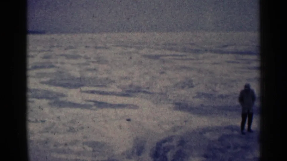 A lone person remains on the snow in the 1961 Duluth footage, framed against a large, muted winter expanse.