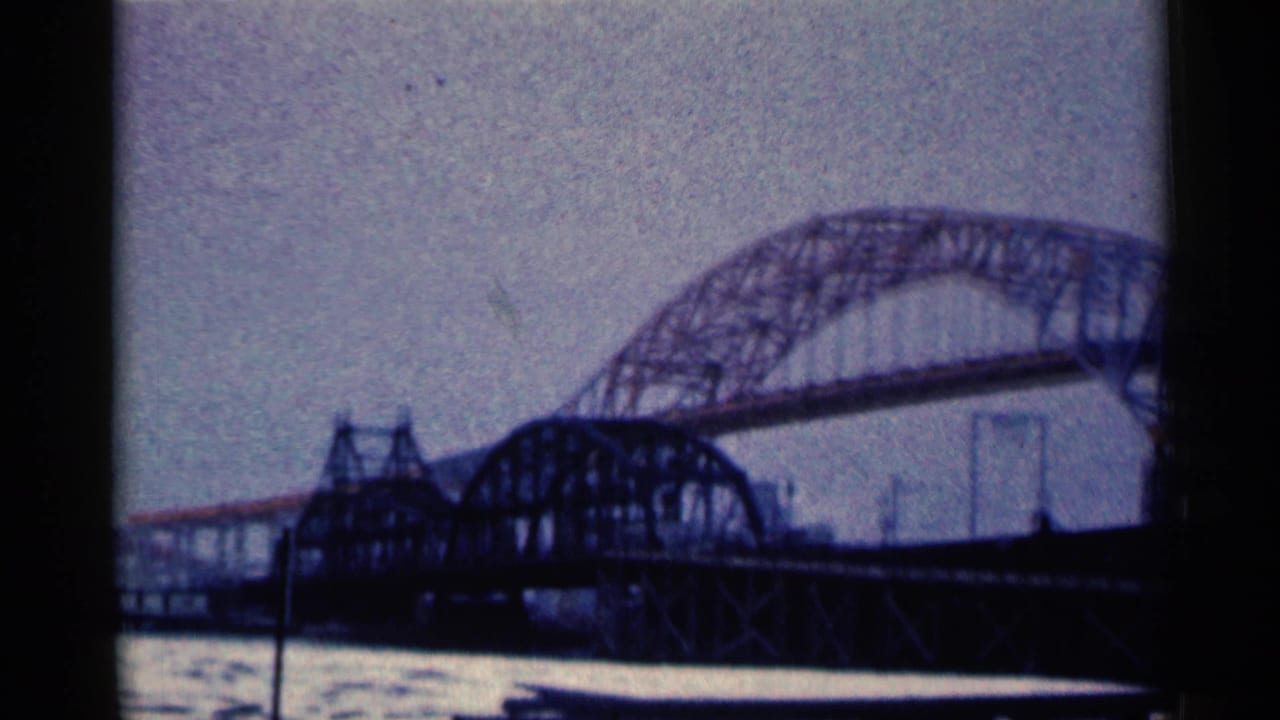 Steel arch bridge over a river beneath a pale sky.