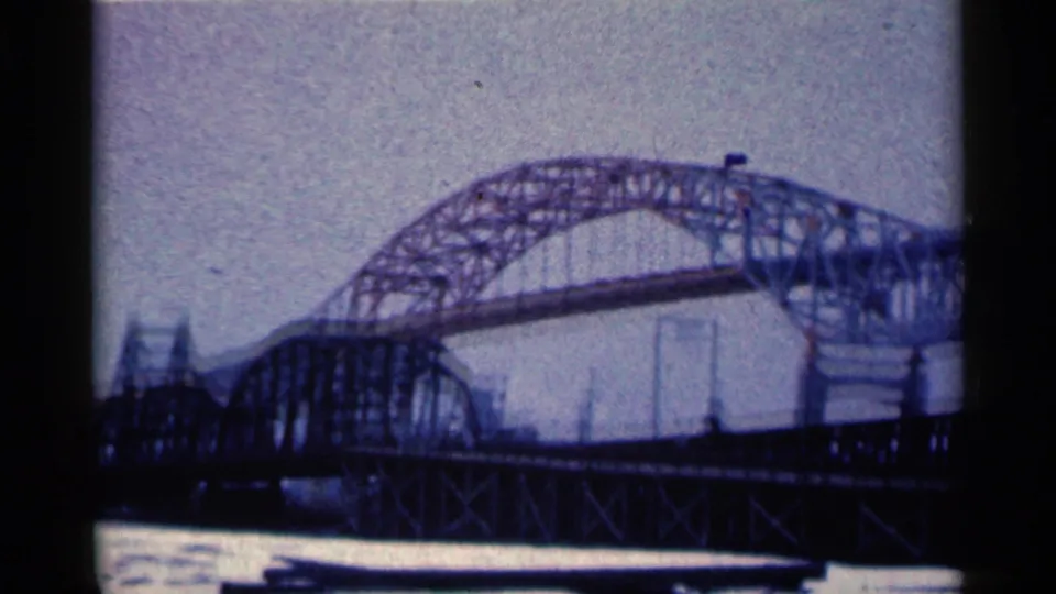 A closer 1961 Duluth frame shows the steel arch and adjoining truss sections stretching across the river.