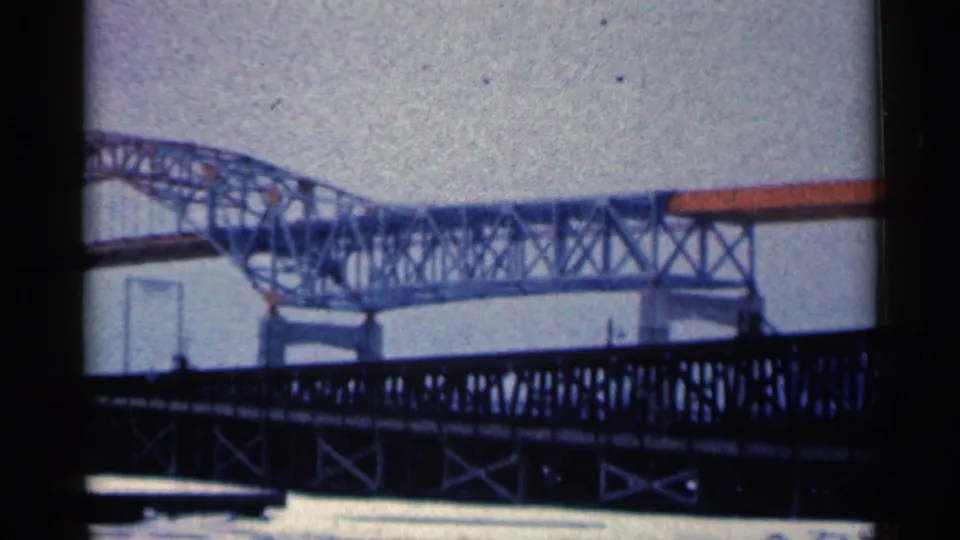 Duluth, Minnesota 1961 frame with a foreground truss bridge silhouetted against a larger pale steel bridge and open sky.