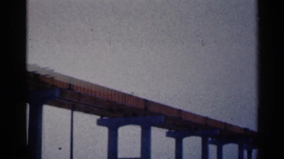 8mm frame from 1961 Duluth showing the underside of a bridge under construction and repeated concrete pilings.
