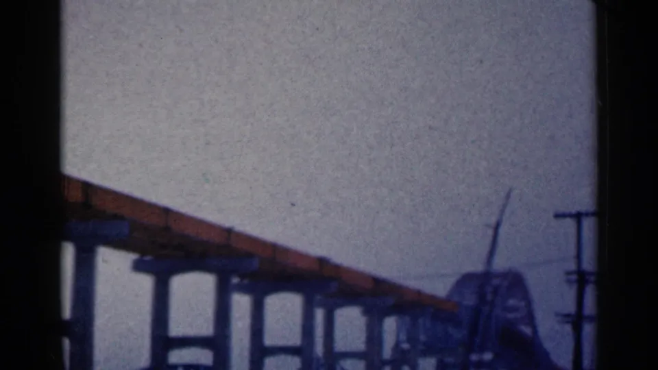 1961 Duluth frame with the elevated bridge continuing toward a distant arched structure beside utility poles.