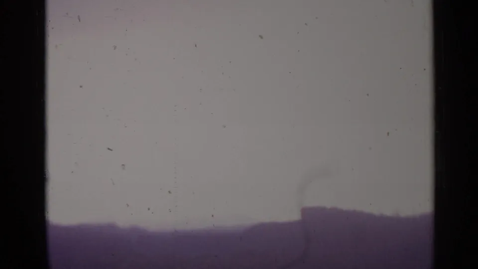 The clip ends on a hazy rural horizon in Spain, with a pale sky and soft purple 8mm color shift.