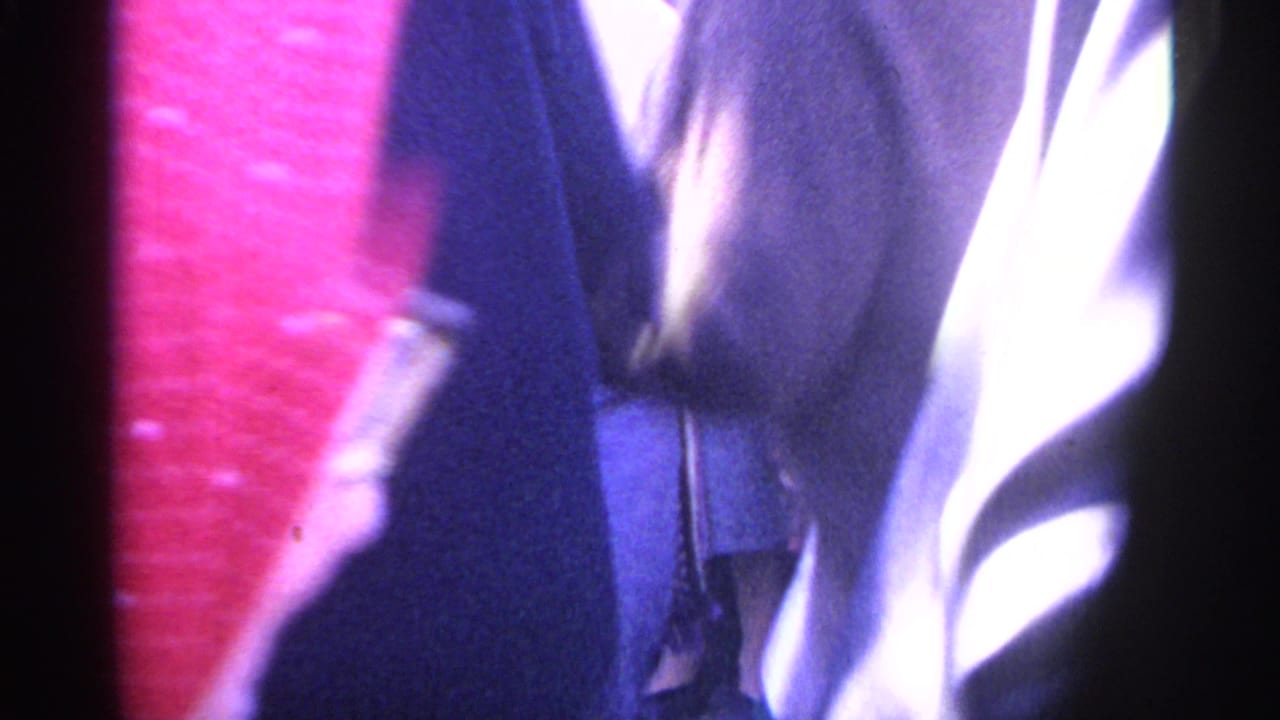 Close, blurred view of people in a crowd beside a red polka-dot garment.