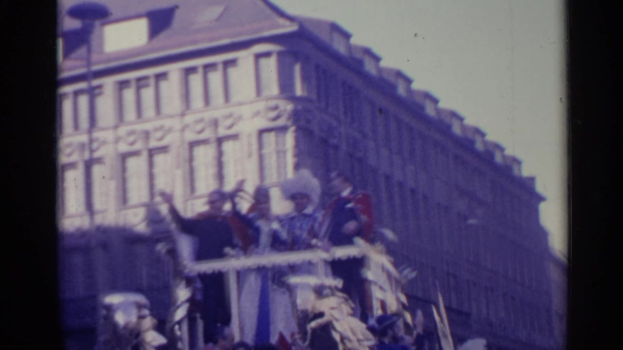 Decorated parade float with figures standing behind eagle ornaments on a city street.