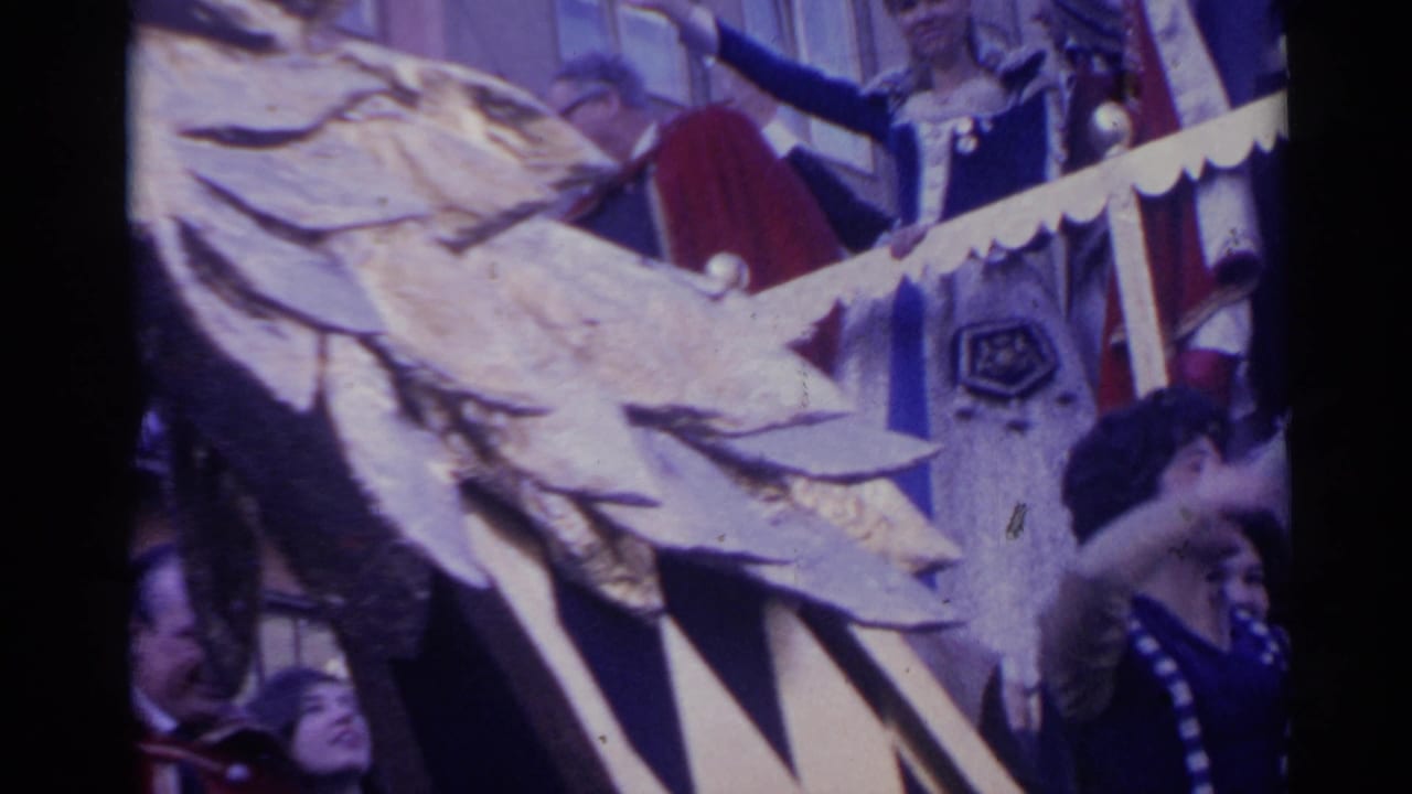 Close 8mm view of the ornate eagle-headed float in Spain, with faces and costume details partly obscured by the decoration.