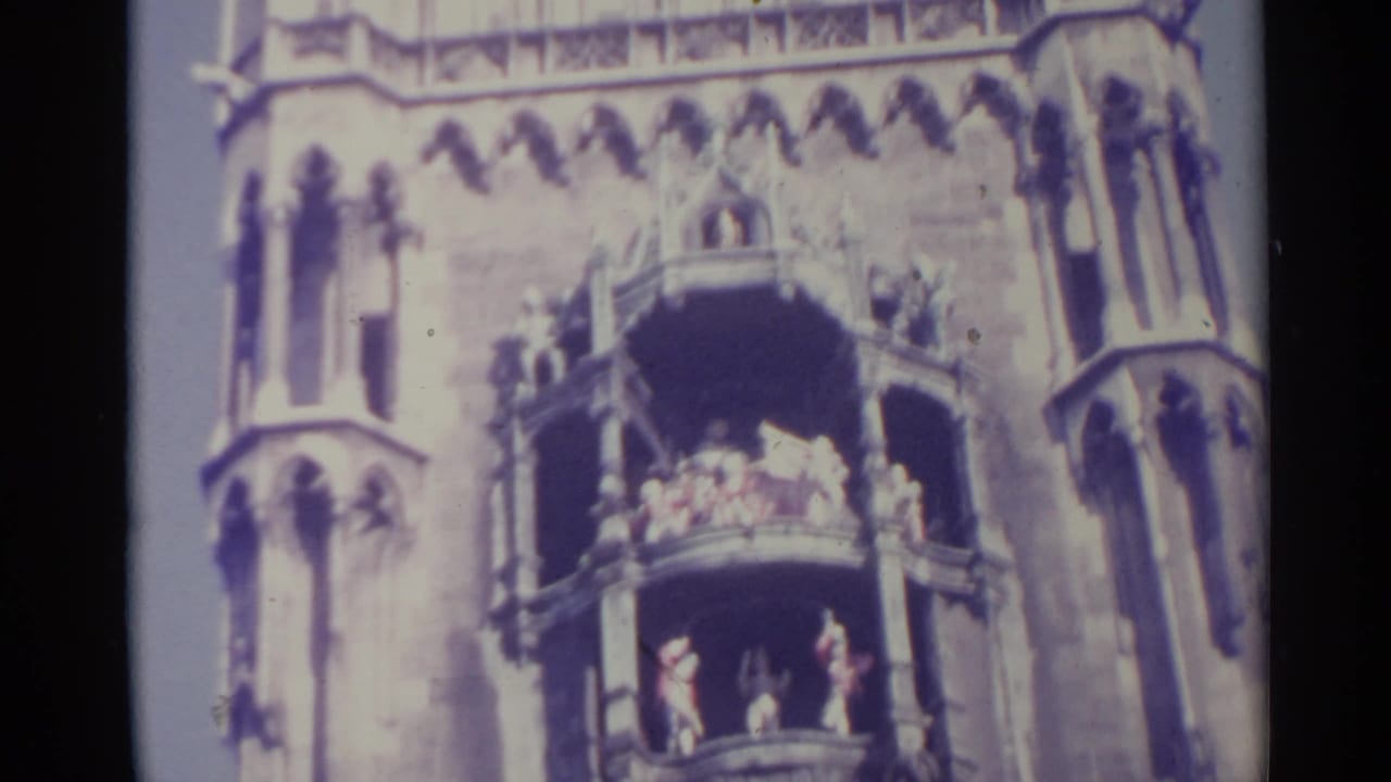 Gothic-style stone facade with tiered balconies and small figures visible.