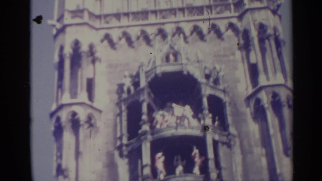 1961 Spain 8mm frame of a Gothic-style facade, with distant people gathered on two balcony levels.