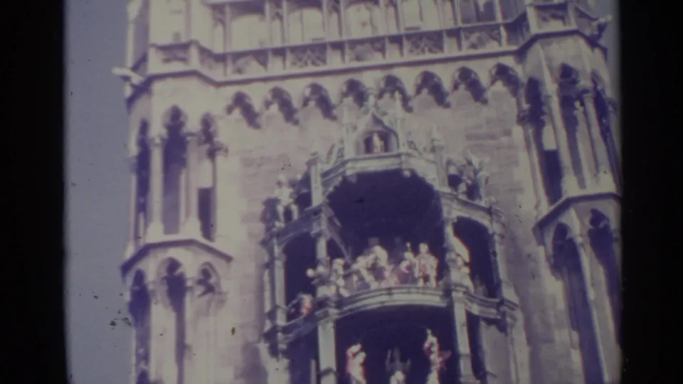 1961 Spain 8mm frame showing stacked balconies and distant figures against an ornate Gothic-style stone facade.