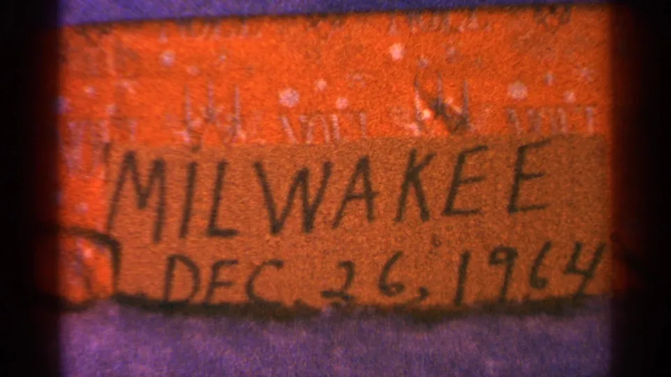 8mm frame showing the handwritten Milwaukee Dec. 26, 1964 label with dark frame edge and grain.
