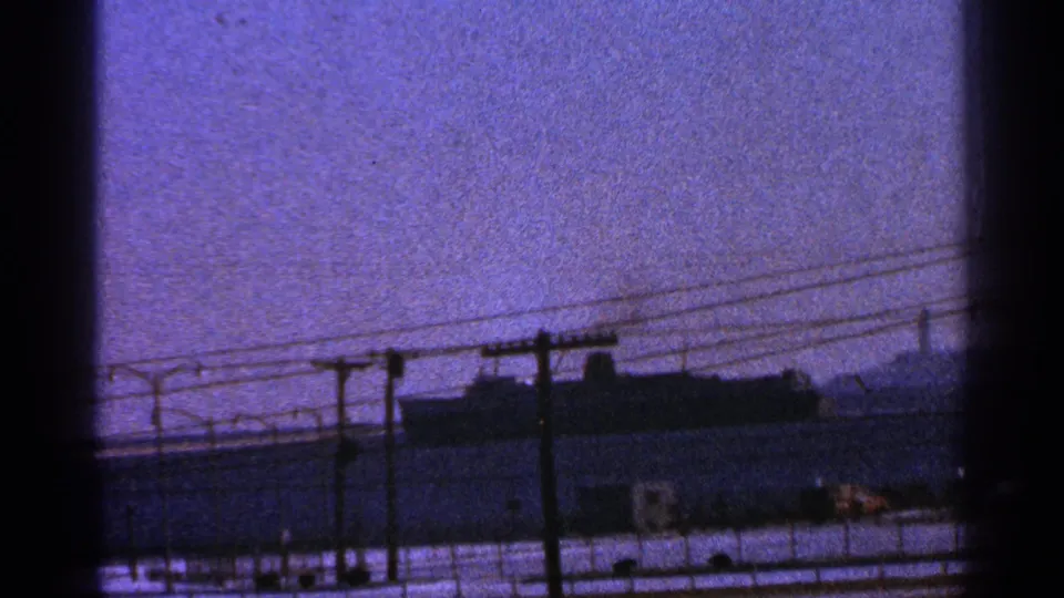 Final frame shows the large vessel farther along the Milwaukee waterfront, partly obscured by poles, wires, and dark frame borders.