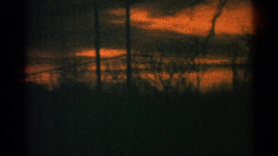 1964 Milwaukee 8mm frame shifting from holiday decor to an abstract orange sunset seen through glass and dark vertical lines.