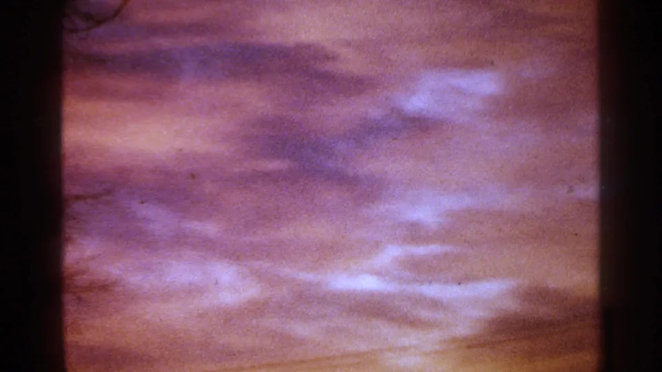 1964 Milwaukee home-movie frame with purple cloud cover and warm orange light near the horizon at day's end.