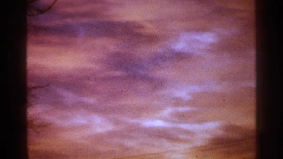 1964 Milwaukee 8mm frame showing saturated pink and purple storm clouds with dark vertical edge shadows.