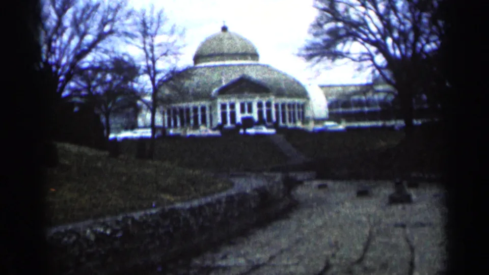 1964 Minnesota 8mm frame with grainy color and soft focus on a domed building behind a path.
