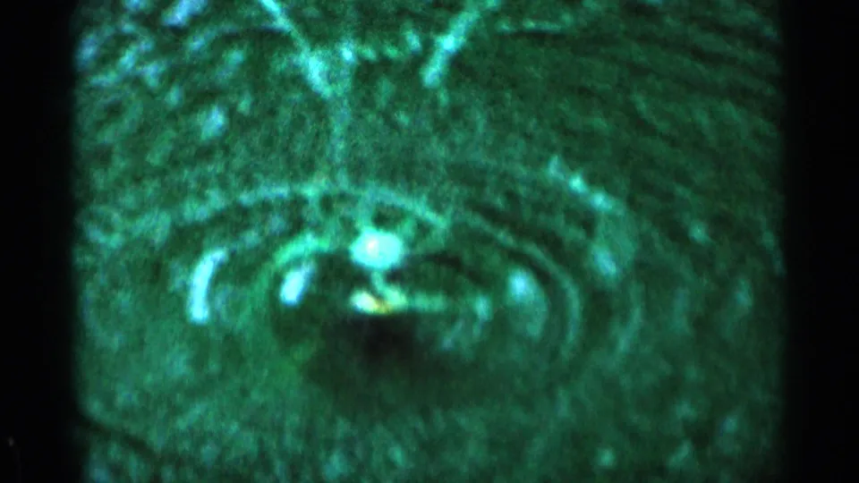 Final 8mm frame of the Minnesota lawn sprinkler, with curved water arcs and a strong green film cast.