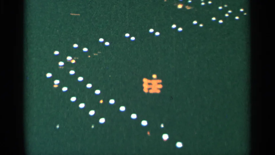 1964 Minnesota 8mm frame showing clustered white lights across a dark green field, with a small orange illuminated shape below center.