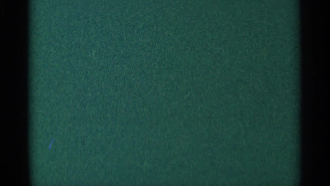 Dark green film frame with faint scattered lights and black frame edges.