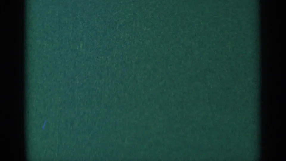 Minnesota 1964 8mm frame with a dark green night field, faint points of light, and heavy black edge areas.